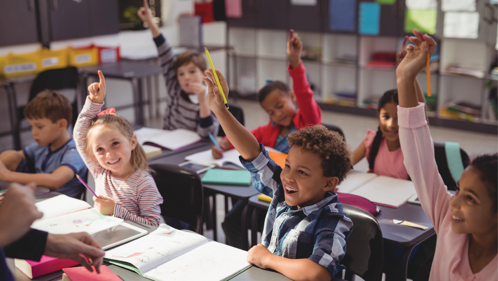 Children raising their hands in a healthy school building
