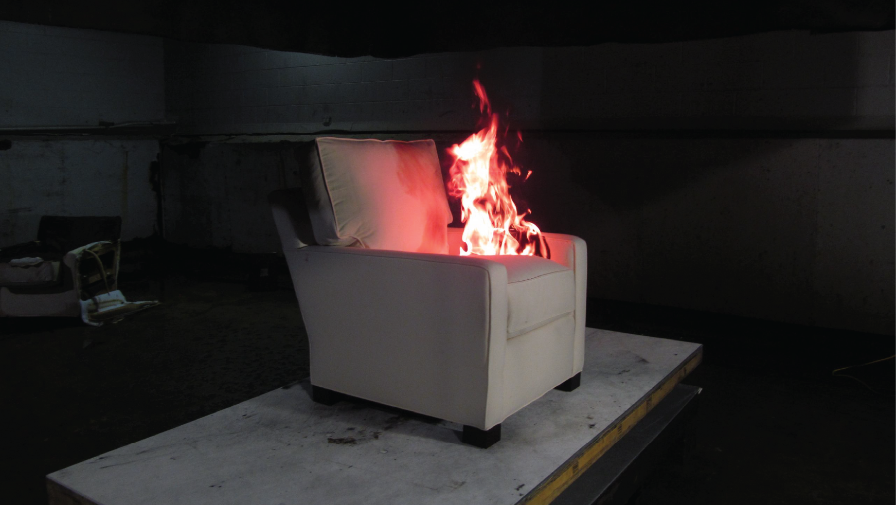 Upholstered chair burning during an experiment