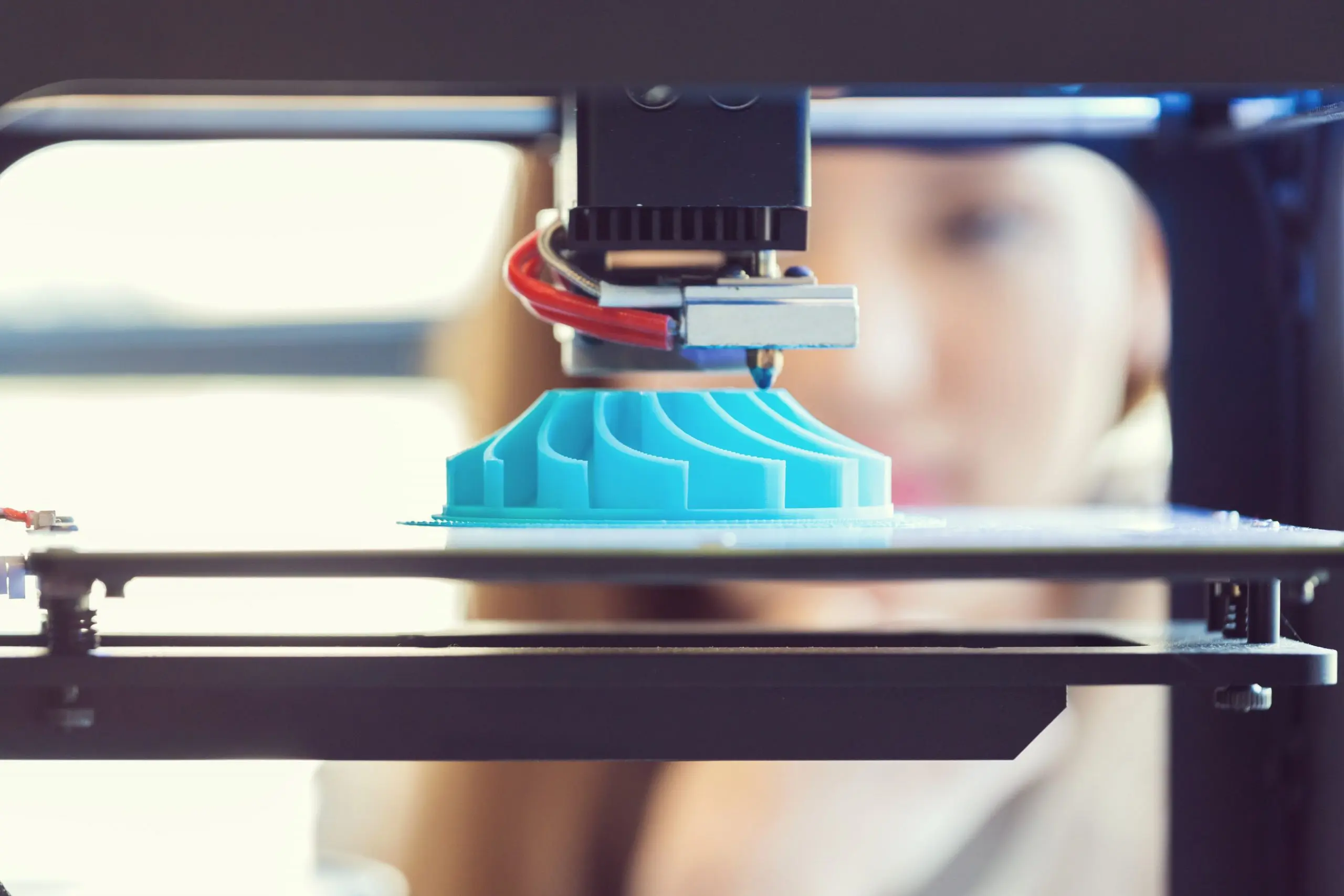 Young woman watching 3D printout.
