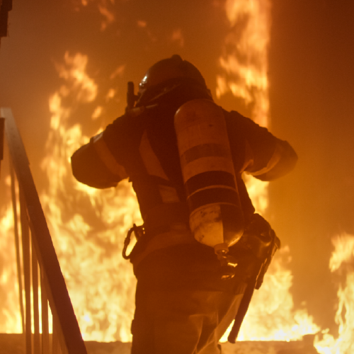 Image of firefighter wearing gear and going through a fire