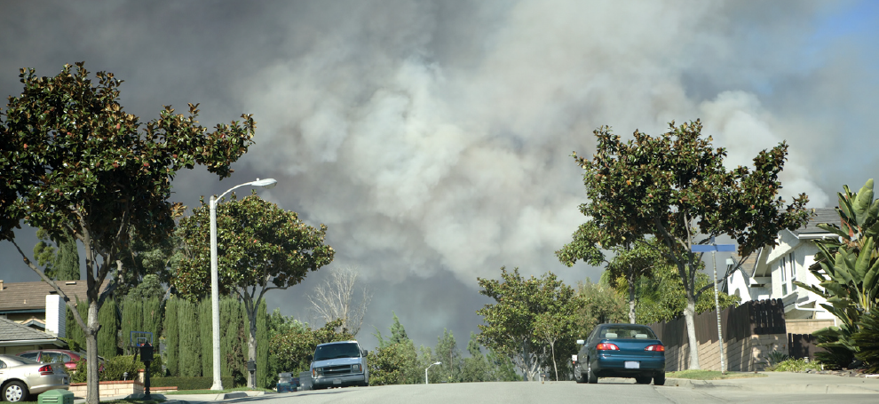 Large plumes of smoke can be seen over a typical Orange County, CA neighborhood.