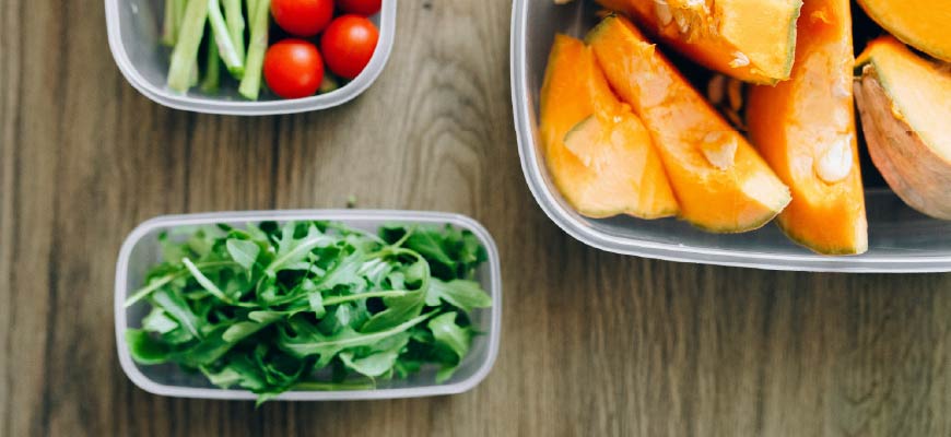 Image of arugula, squash, asparagus and tomatoes in food storage containers