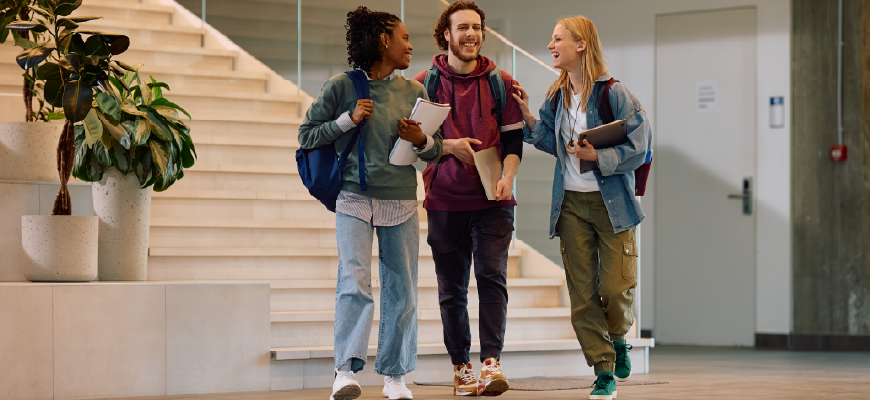Three university students walking together while talking.